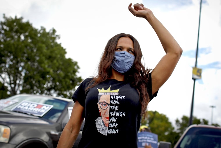 A woman wearing a t-shirt depicting the late Supreme Court Justice Ruth Bader Ginsburg listens to U.S. Democratic vice presidential nominee Senator Kamala Harris in Miami