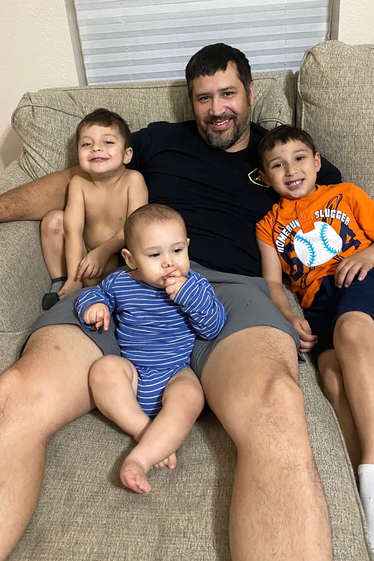 Image: Robert Villegas cuddled sons Robert Jr. (left), Nicholas and Ayden in December 2020, weeks before he fell ill with covid-19 and died. "You can go explain to my 1-, 3-, and 5-year-old that their daddy is not coming home," his widow, Valerie Villegas