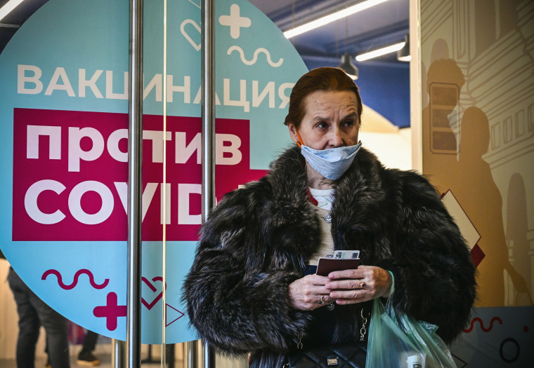 Image: A woman waits to receive an injection of Russia's Sputnik V vaccine against the coronavirus disease at a vaccination point at the GUM department store in Moscow