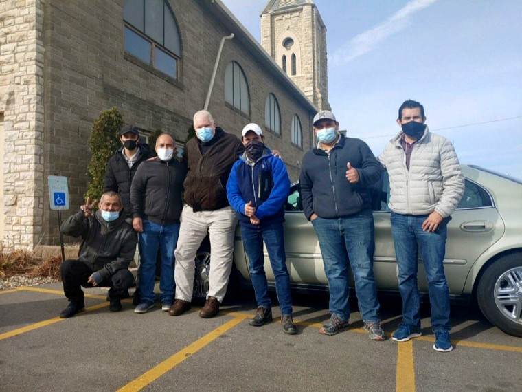 The six construction workers from Texas who stopped receiving pay for their work in Cedar Rapids, Iowa flank John Greve, pastor of Grace Episcopal Church, who fed and housed them after the learning of their situation.