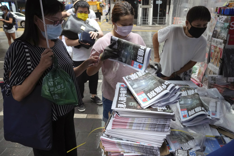 Image: People queue up to buy last issue of Apple Daily at a newspaper booth at a downtown street in Hong Kong