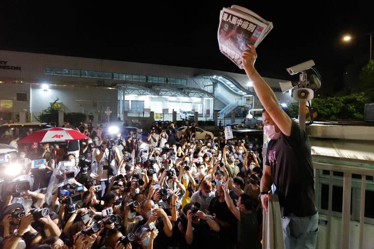 Image: An Apple Daily journalist holds freshly-printed copies of the newspaper's last edition to be distributed to supporters gathered outside their office in Hong Kong