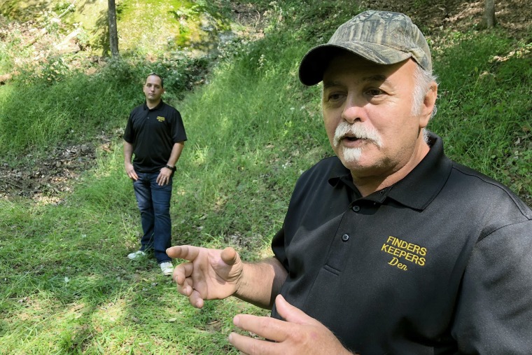 Dennis Parada, right, and his son Kem Parada stand at the site of the FBI's dig for Civil War-era gold in Dents Run, Pa., on Sept. 20, 2018.