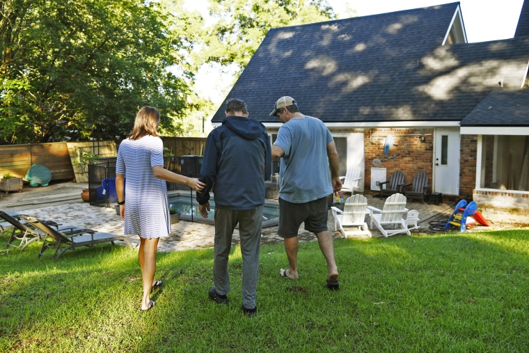 Image: Christian Dickinson and Morgan Champion help Morgan's father, Jim, down a hill in their backyard.