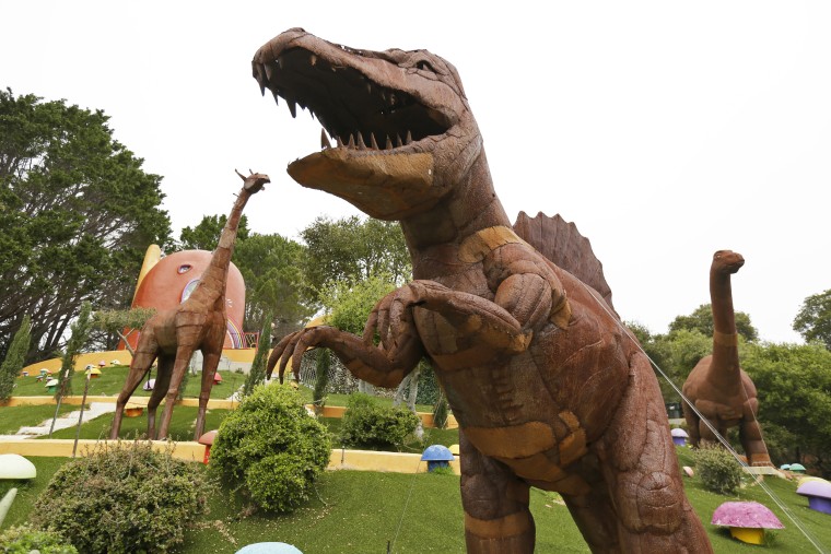 Dinosaurs and other figurines stand in the backyard of the Flintstone House in Hillsborough, Calif., on April 1, 2019.