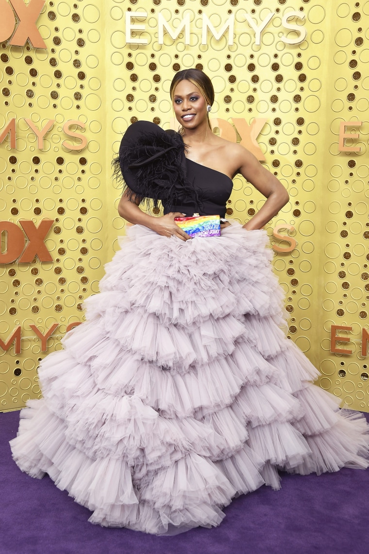 Laverne Cox wearing a dress on a yellow background