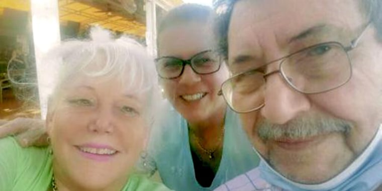 Raysa Rodriguez, center, with her neighbors Dick Augustine and Elaine Sabino, who lived in apartment 1210 and are still unaccounted for.