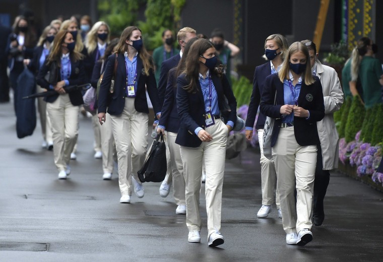 Image: Officials walk past an order of play board before the start of play at Wimbledon, London