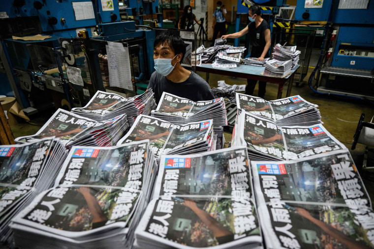 Image: Apple Daily employees work in the printing room as the last edition of the newspaper is printed in Hong Kong