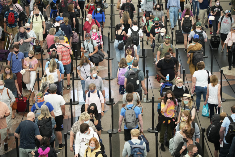 Travelers queue up in long lines to pass through the south security checkpoint in Denver International Airport on June 16, 2021, in Denver.