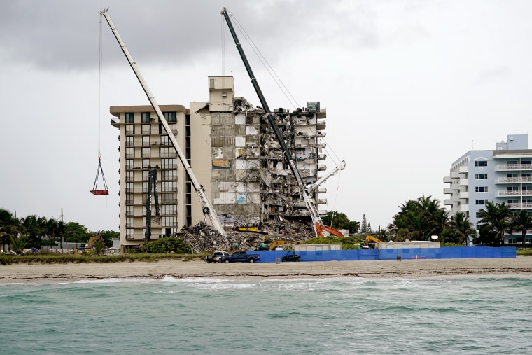 Image: Search and rescue personnel work alongside heavy machinery to sift through the rubble at the Champlain Towers South condo building, where scores of people remain missing almost a week after it partially collapsed on June 30, 2021, in Surfside, Fla.