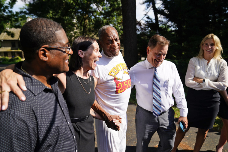 Image: Bill Cosby, center, listens to members of his team speaks with members of the media outside Cosby's home in Elkins Park, Pa., on June 30, 2021, after Pennsylvania's highest court overturned his sex assault conviction.