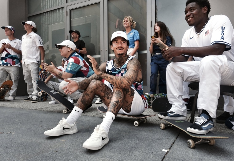 Image: Nyjah Huston, center, laughs with teammate Zion Wright, right, before they are introduced with the rest of the first U.S. Olympic skateboarding team