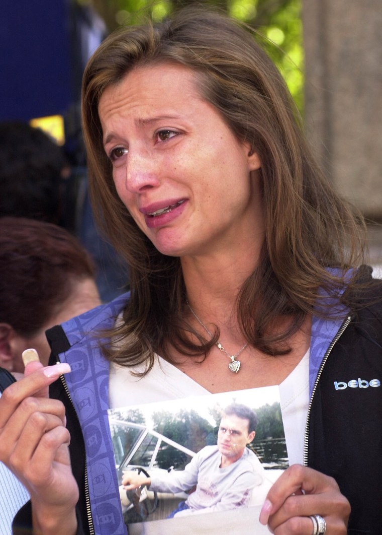 New York City--The pain is etched on Monica Iken's face as she holds pix of her husband Michael Iken