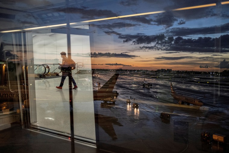 Image: A passenger arrives at the airport as Hurricane Elsa moves towards south Florida, in Miami