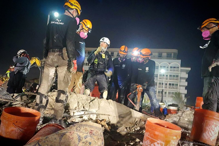 First responders with Israeli relief organization SmartAID's Magen search-and-rescue team sift through the rubble of the Champlain Towers South complex in Surfside, Fla.