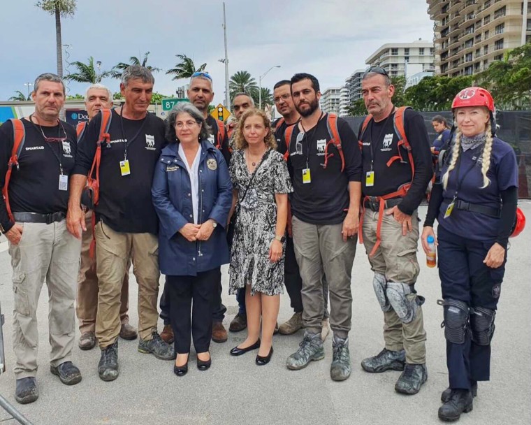 Israeli relief organization SmartAID's Magen search-and-rescue team and Dr. Alison Thompson stand with Miami-Dade County Mayor Daniella Levine Cava at the Champlain Towers South complex in Surfside, Fla.