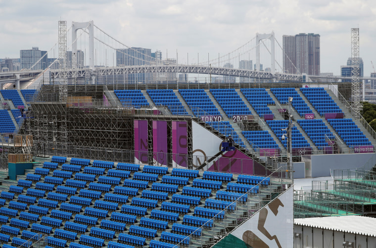 Construction workers are seen around spectators' seats in preparation for the Tokyo 2020 Olympic Games