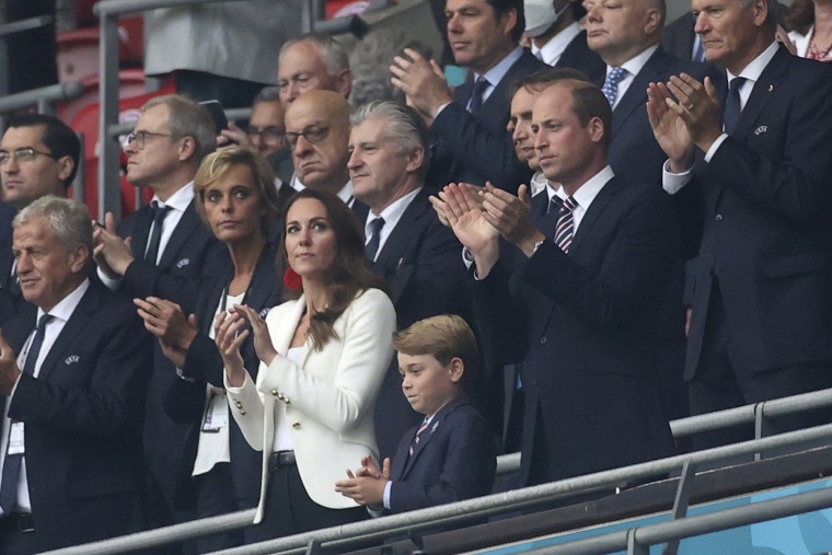 Britain's Prince William, foreground right, with his wife Kate and their son Prince George, center, applaud during the ceremony before the Euro 2020 soccer championship final match between England and Italy at Wembley stadium in London, Sunday, July 11, 2021.