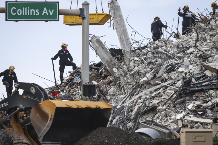 IMAGE: Rescuers search for victims at a collapsed condo building in Surfside, Fla.