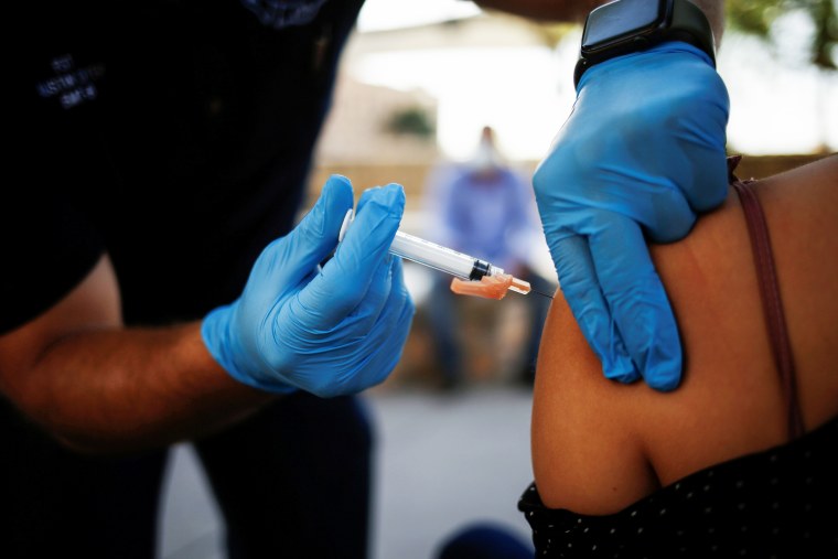A healthcare worker from the El Paso Fire Department administers a Moderna Covid-19 vaccination near the Santa Fe International Bridge in El Paso, Texas, on May 7, 2021.