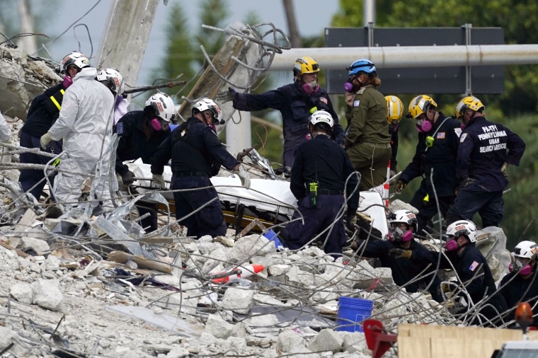 Image: Rescue workers move a stretcher containing recovered remains at the site of the collapsed Champlain Towers South condo building, in Surfside, Fla., on July 5, 2021.