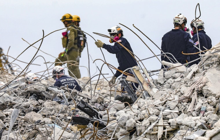 Search and rescue team members dig through the rubble of the Champlain Towers South condo building.