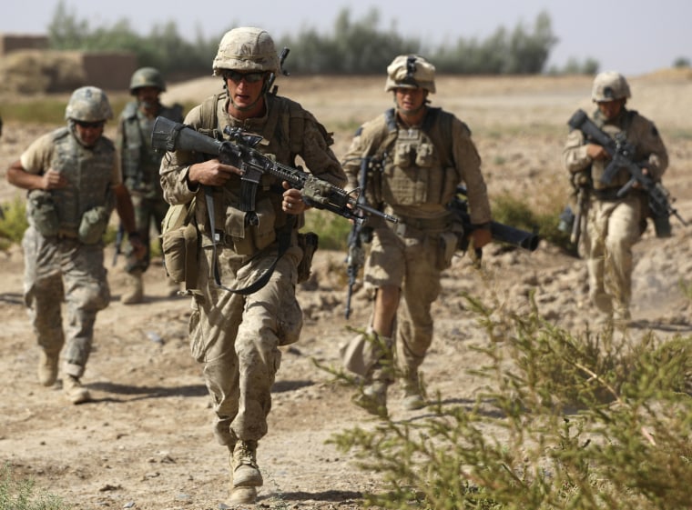Image: U.S. Marines with an Afghan soldier, and an interpreter, left, uring a firefight with Taliban militants in Nawa district, Helmand province
