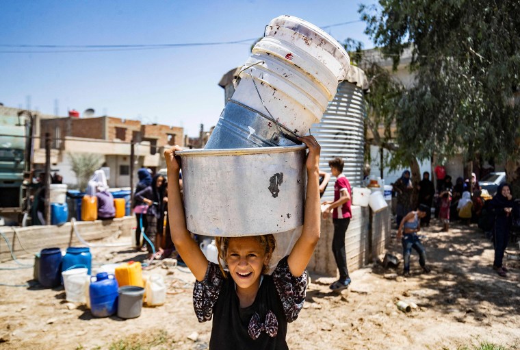Image: Syrian child carries containers to collect water provided by the UNICEF in Syria's northeastern city of Hasakeh,