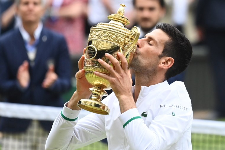 Serbia's Novak Djokovic celebrates with the trophy after winning his Wimbledon final match against Italy's Matteo Berrettini on July 11, 2021.