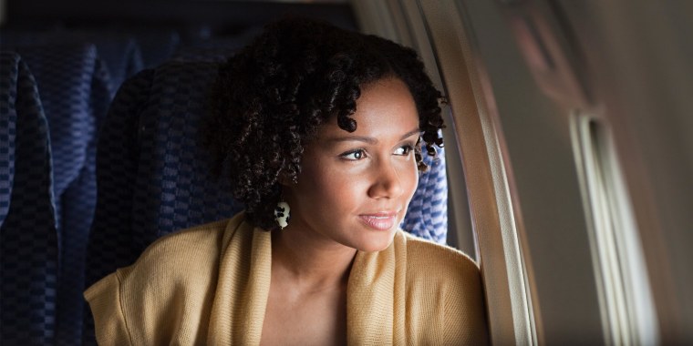 Female airplane passenger looking out of window