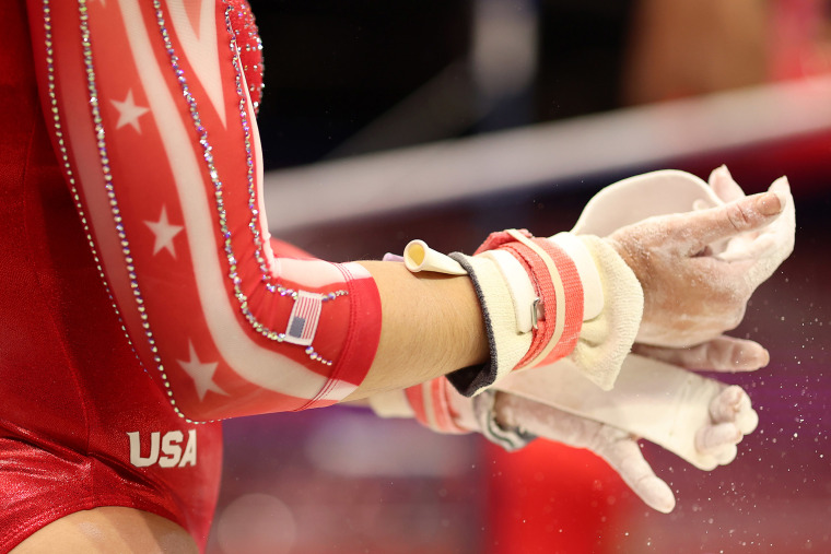 Kayla DiCello puts chalk on her hands during warm ups