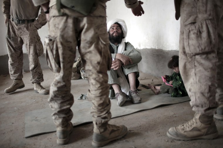 Image: A local Afghan imam listens to an interp