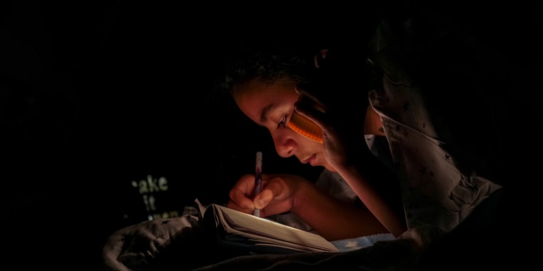 Image of a girl Holding Book and a flashlight