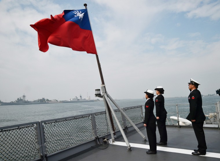 Image: Taiwanese sailors salute the island's flag on the deck of the Panshih supply ship after taking part in annual drills, at the Tsoying naval base in Kaohsiung.