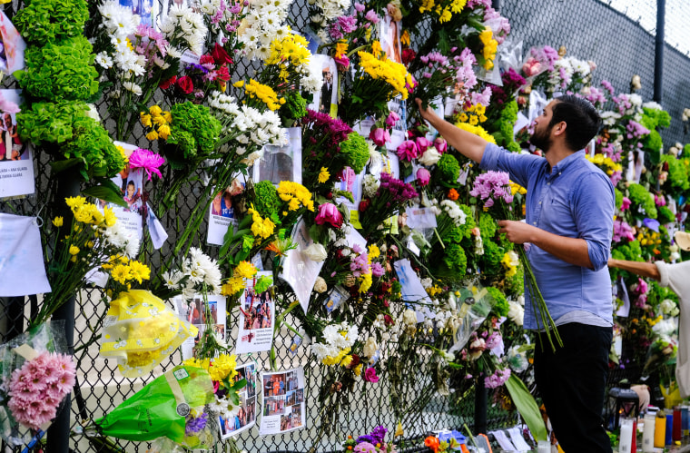 Image: Leo Soto places flowers onto a makeshift memorial