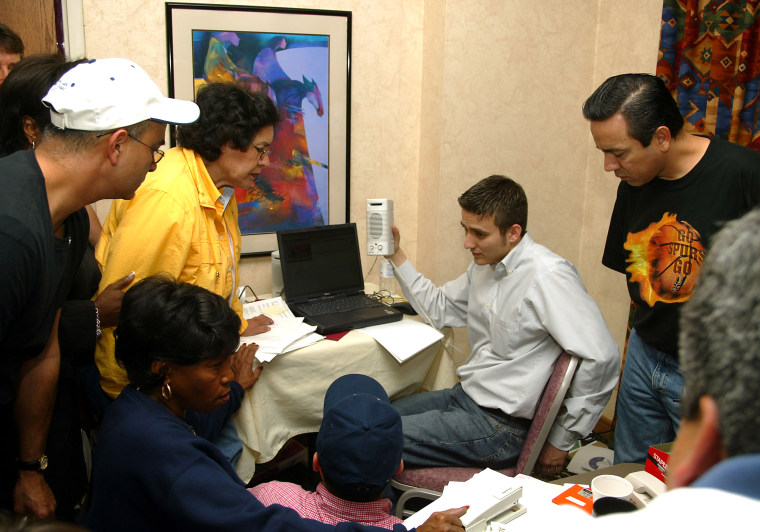 Jeff Rotkoff holds up a computer speaker so House Democrats can hear a news conference in 2003