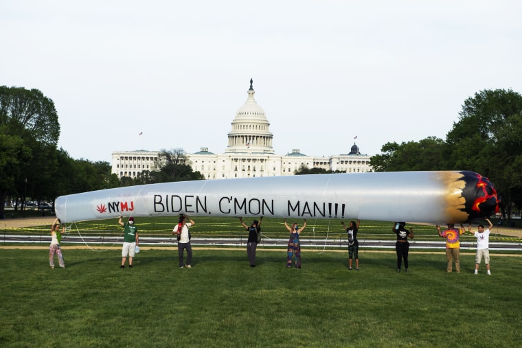 Members of the DC Marijuana Justice community hold a blow-up joint on the National Mall to call on President Joe Biden to take action on legalization and expungement of criminal records on April 28, 2021.