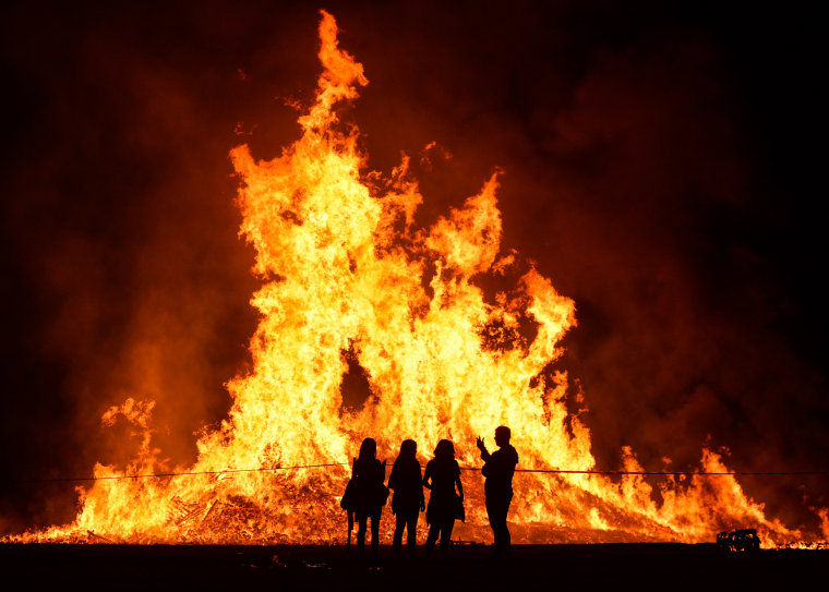 Image: People in front of a bonfire during the Eleventh Night marking the start of the unionist Twelfth celebrations, in Craigy Hill, Larne