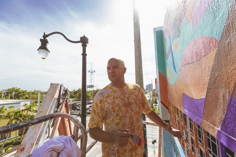 Image: Kyle Holbrook paints a mural in honor of the Surfside victims