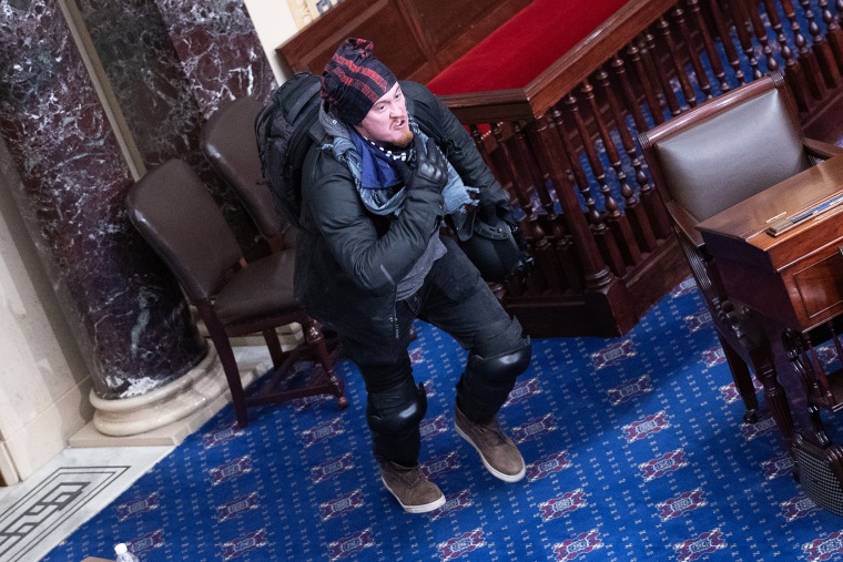 A rioter and supporter of President Donald Trump moves to the floor of the Senate chamber on Jan. 06, 2021.