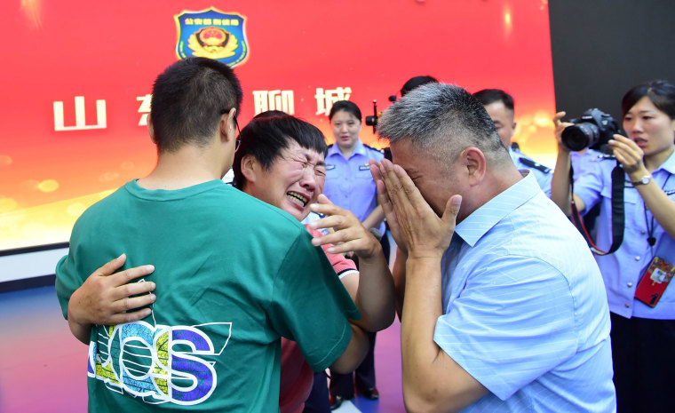 Image: Guo Gangtang and his wife reunite with their son Guo Xinzhen, who was abducted 24 years ago, in Liaocheng