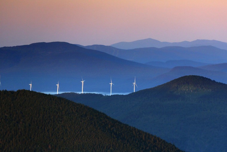 A line of wind turbines catch the breeze at sunrise in the western Maine mountains on July 26, 2017, in Weld, Maine.