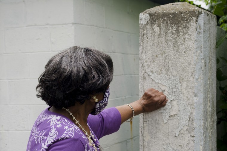 Margaret Watson, 93, touches a section of the Birwood Wall that runs behind her house.
