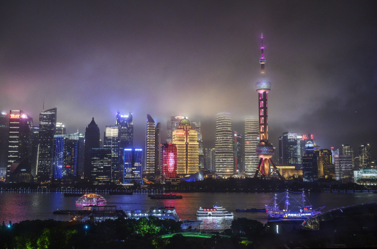 Image: Boats travel on the Huangpu River as the skyline of the city is is seen, including the Oriental Pearl TV Tower and the Shanghai Tower