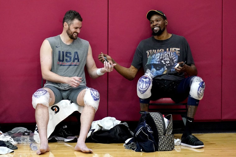 Image: Kevin Love, left, and Kevin Durant laugh while passing a cell phone after practice for USA Basketball on July 7, 2021, in Las Vegas.