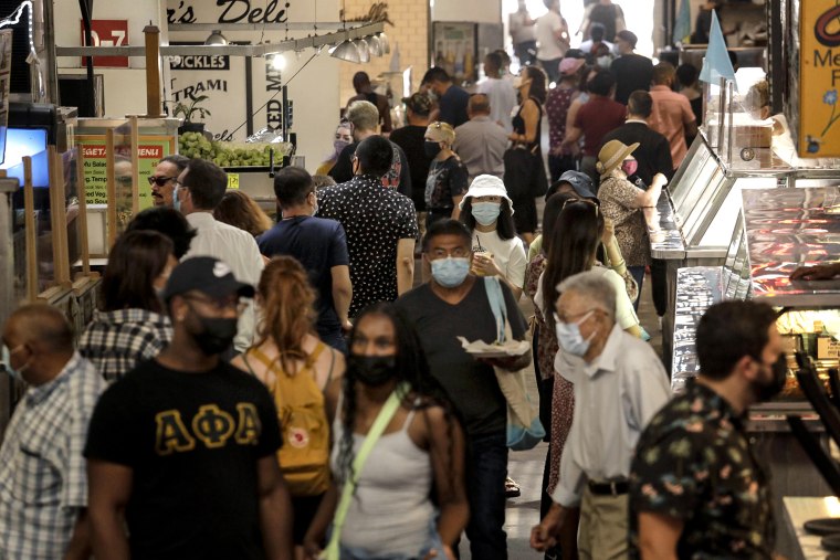 People, many masked, look for lunch at the Grand Central Market in downtown Los Angeles on June 15, 2021.