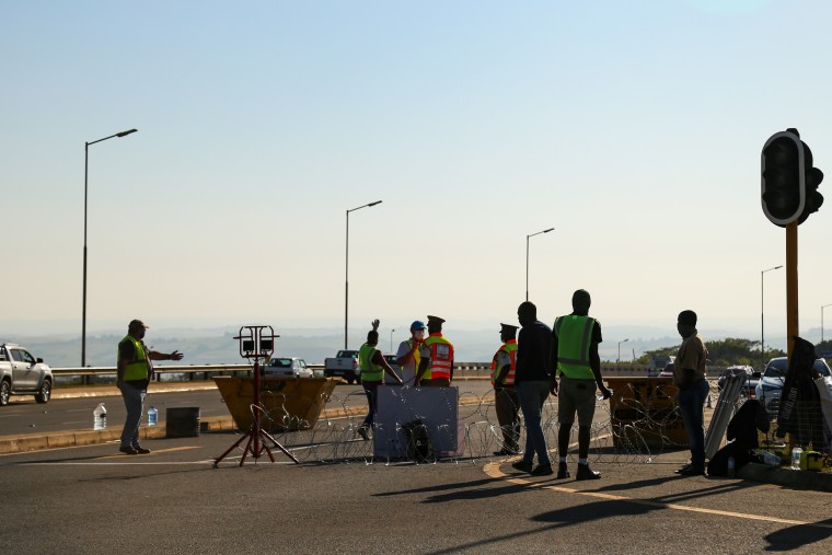 Image: Volunteers man a traffic checkpoint at a highway interchange into a suburb of Durban, South Africa, to prevent unrest after a week of riots.