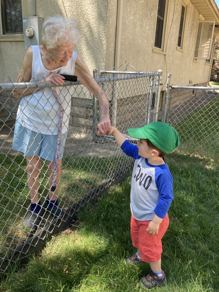 Mary O'Neill and Benjamin Olson have a chat by the fence that separates their homes. 