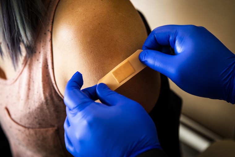 Image: A healthcare worker places a band-aid on a patient after administering a dose of the Pfizer-BioNTech Covid-19 vaccine at Boston Medical Center on June 17, 2021.